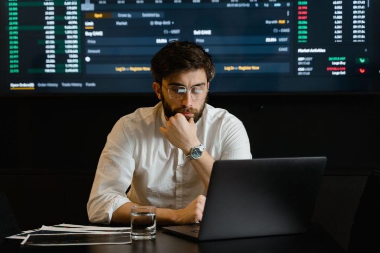 Mastering the First Impression: Your intriguing post title goes here A man intensely analyzing stock market data on a laptop in an office setting.